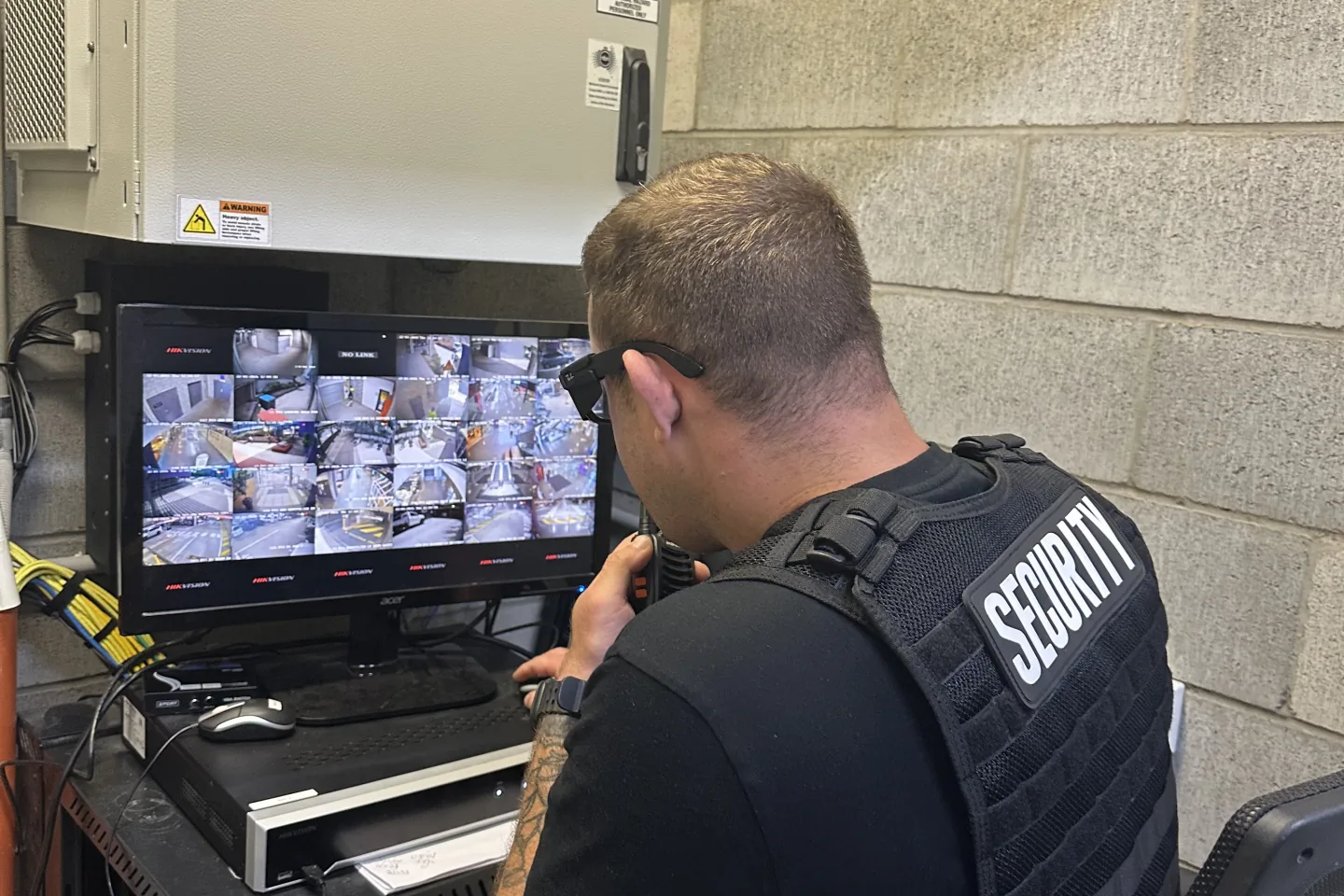 Operator watching a wall of CCTV monitors