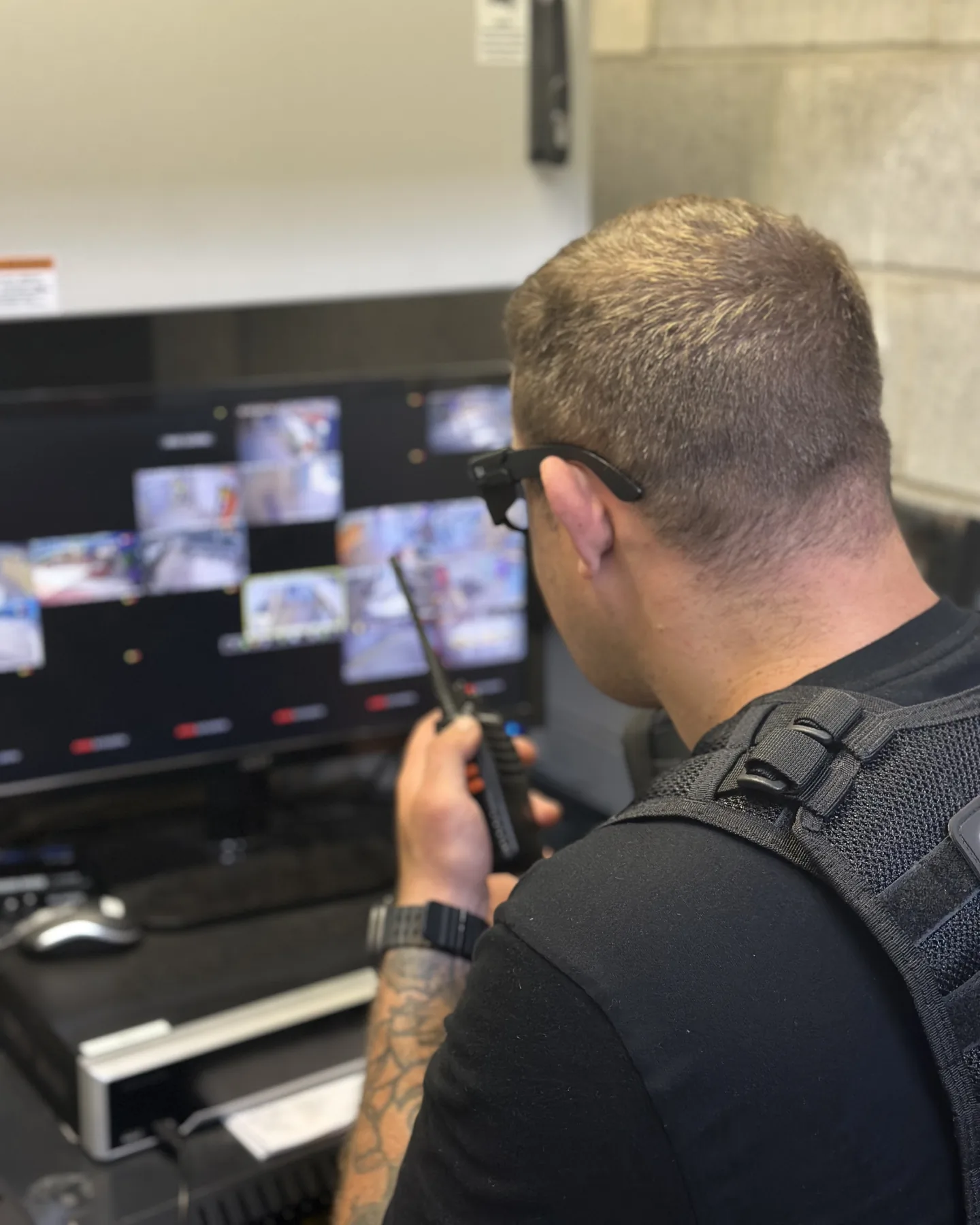 Elite Squad officer with a radio in hand at the CCTV screens, escalating to a patrol