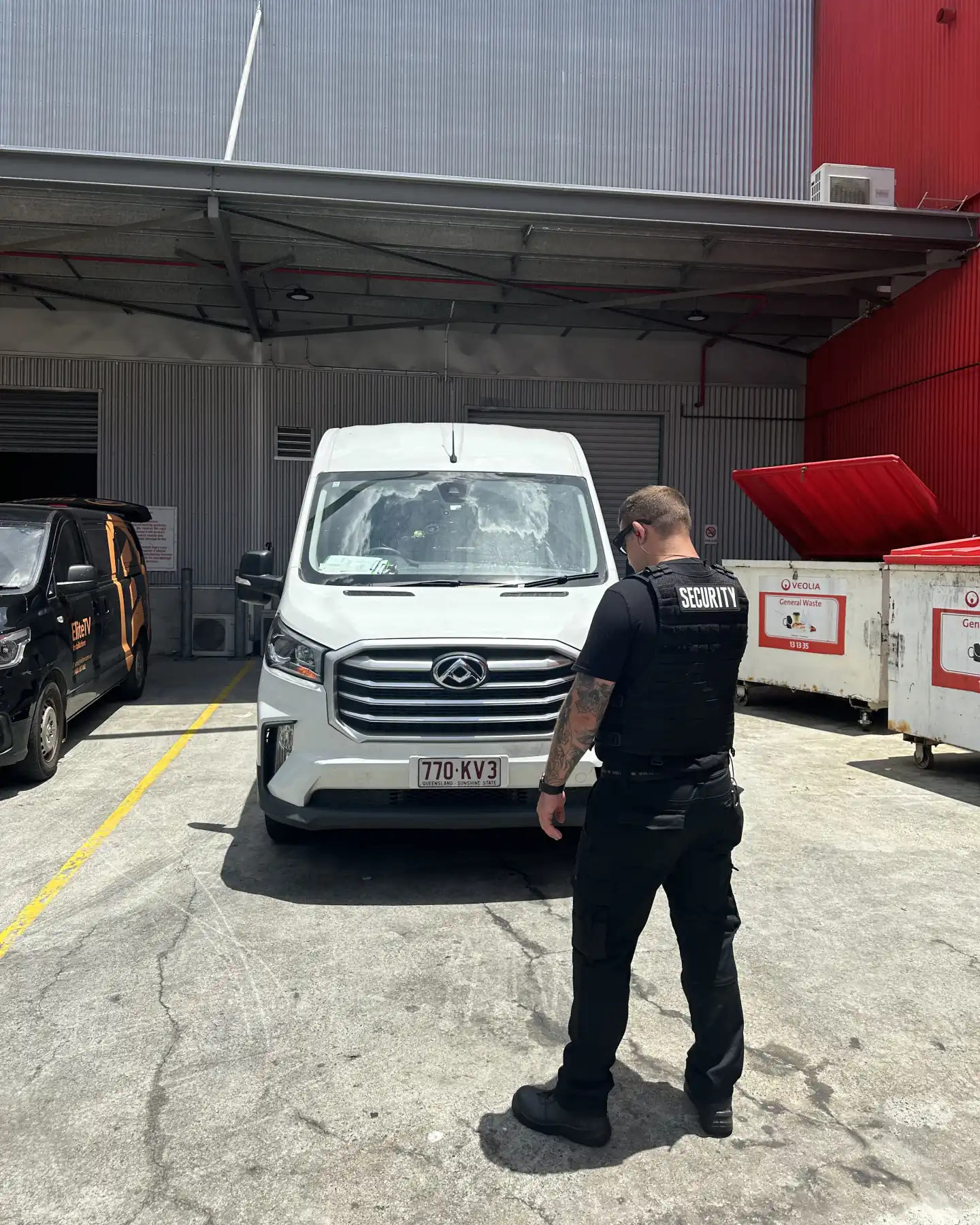 Elite Squad officer at a Brisbane retail centre loading dock beside a delivery van